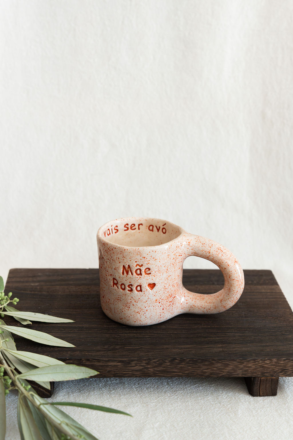 Caneca de cerâmica creme com salpicos laranja e texto vermelho Mãe Rosa e vais ser avó