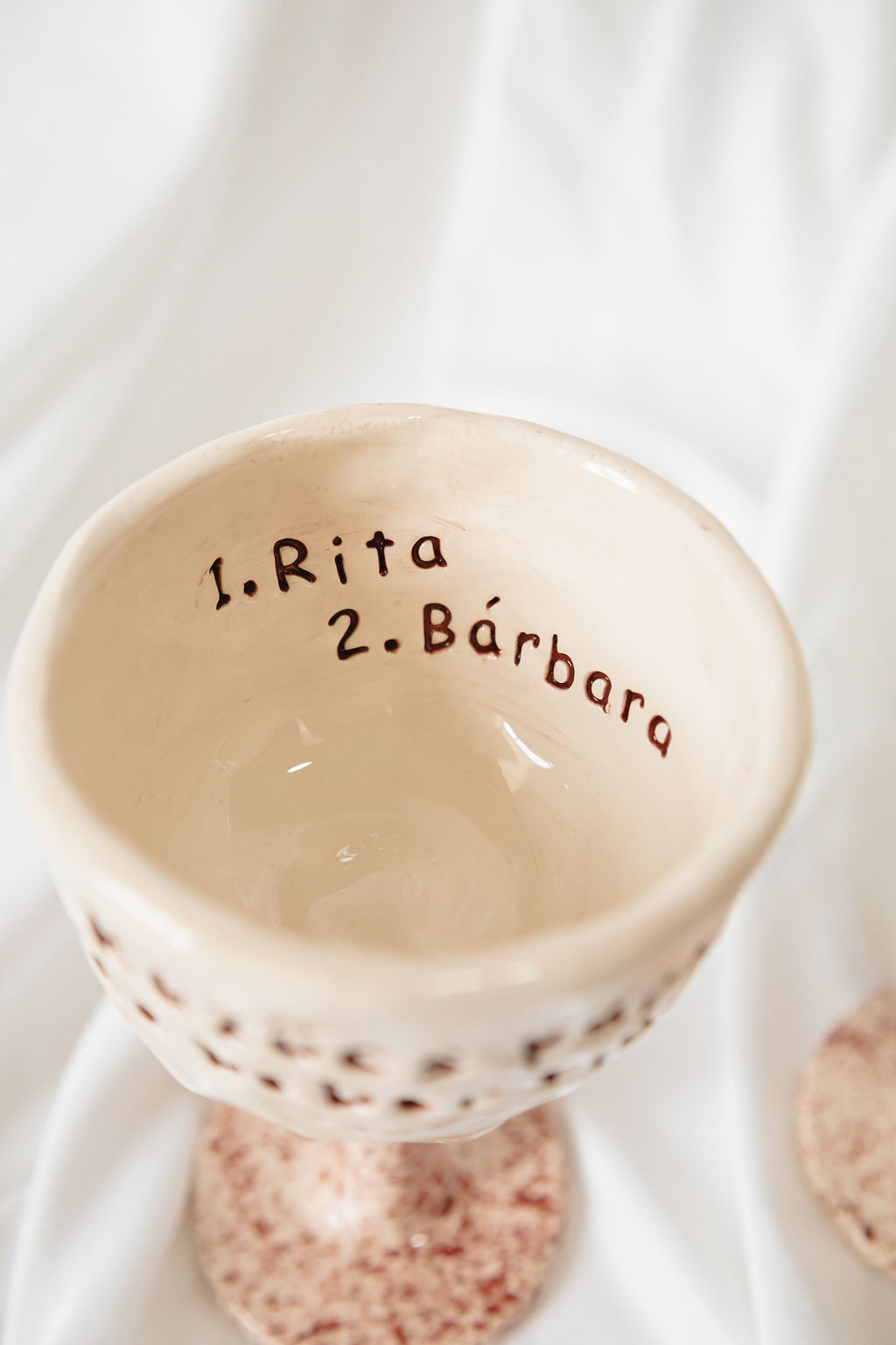 Cálice de cerâmica creme com base rosa marmoreado e nomes escritos no interior