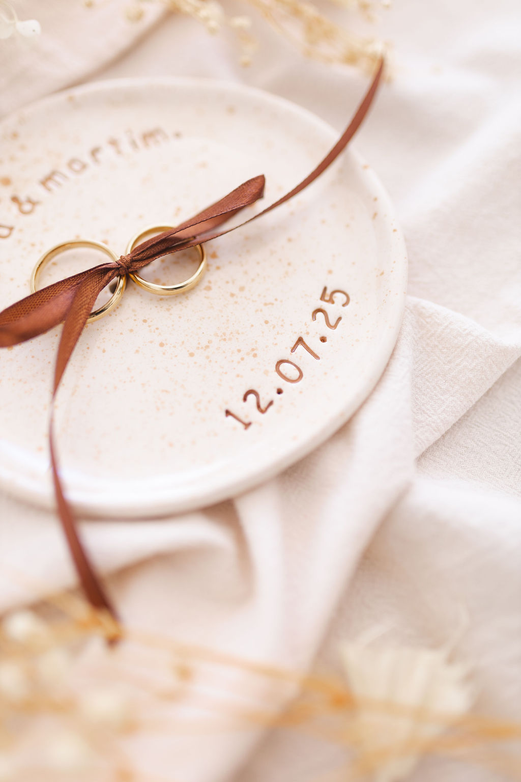 Prato cerâmico branco com anéis dourados e fita castanha