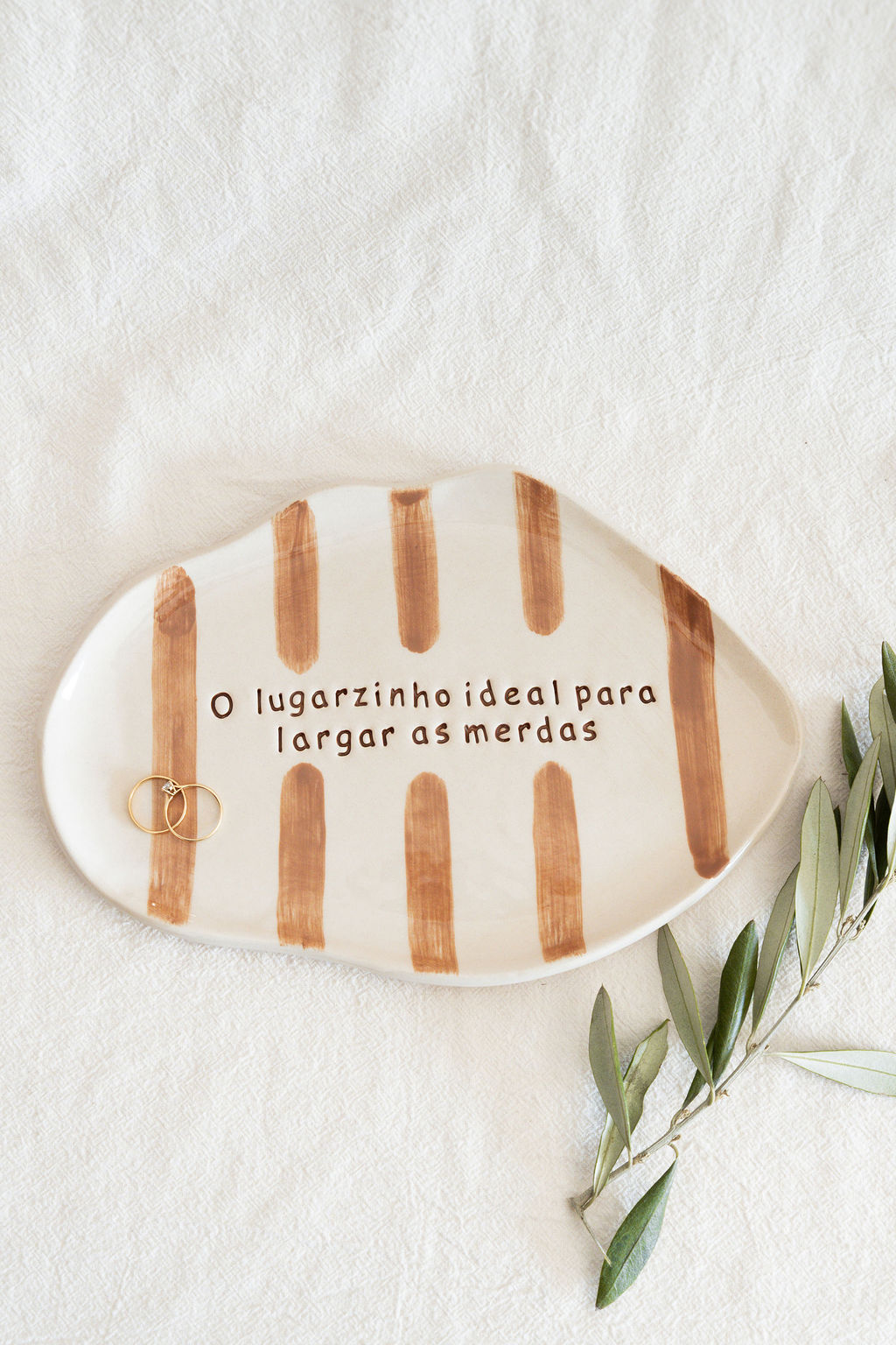 Prato decorativo de cerâmica com riscas castanhas e texto humorístico