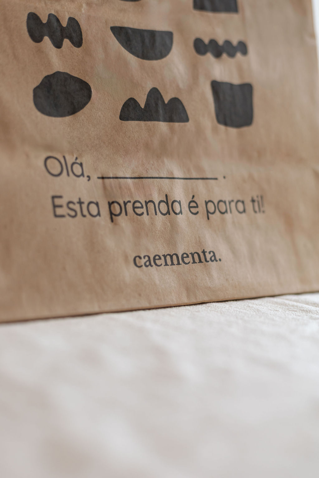 Saco de papel castanho com texto e estampado preto