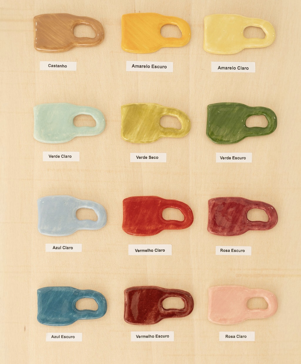 Amostras coloridas de placas cerâmicas em forma de canecas com etiquetas de cores