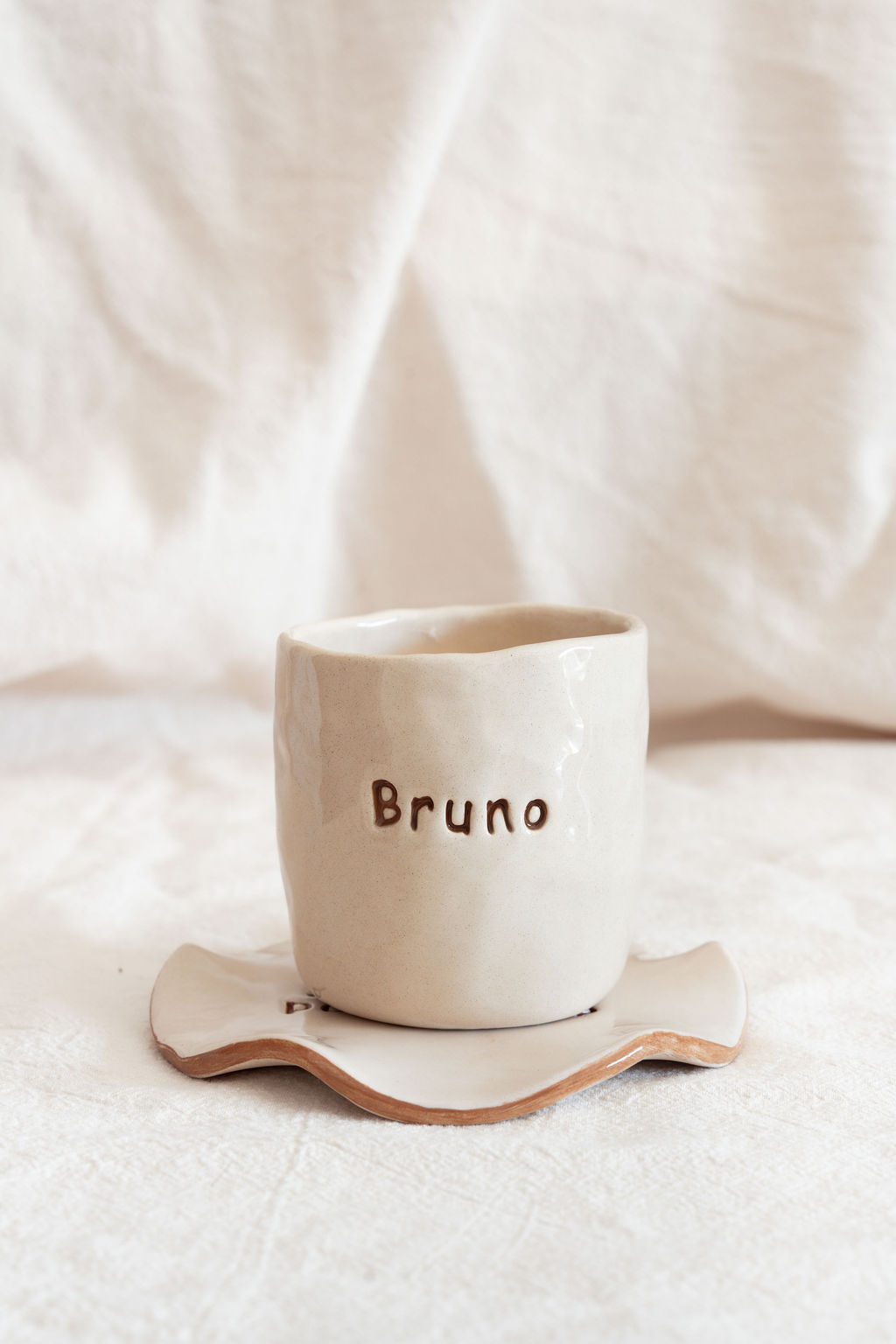 Cálice de cerâmica com a palavra Bruno e pires branco irregular