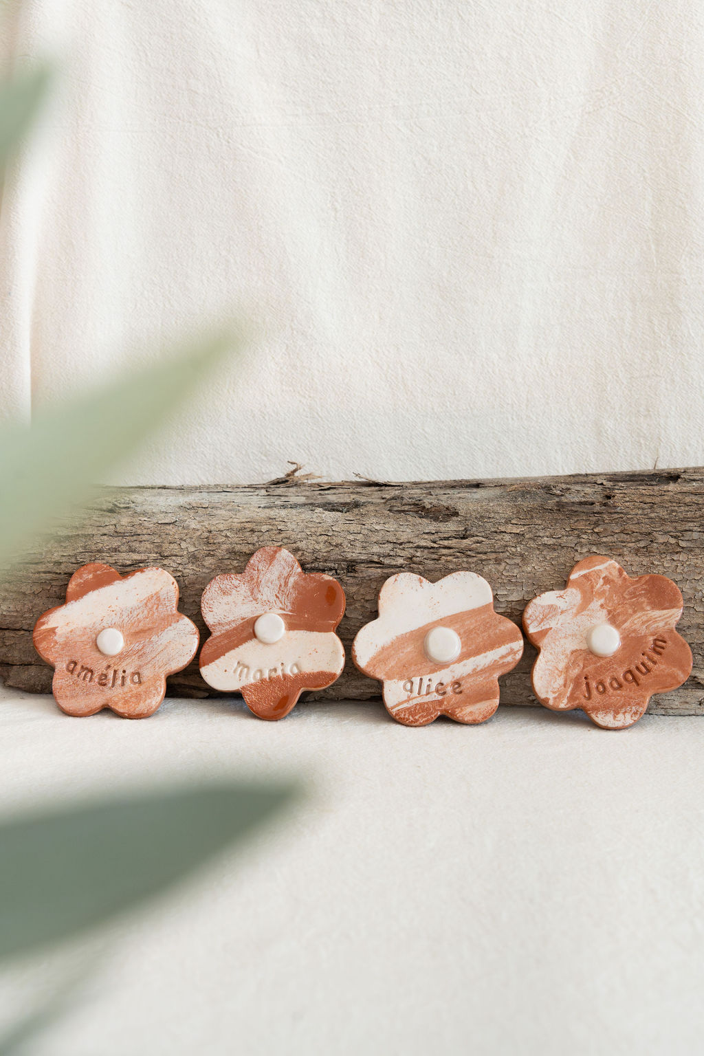 Flores de cerâmica bicolor com nomes escritos e botão branco no centro