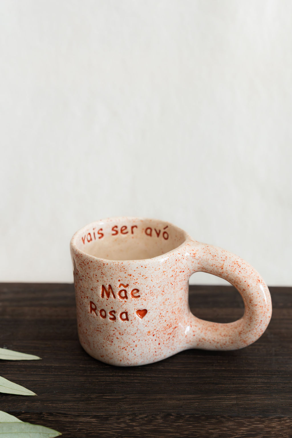 Caneca de cerâmica creme com manchas laranja e textos Mãe Rosa e vais ser avó