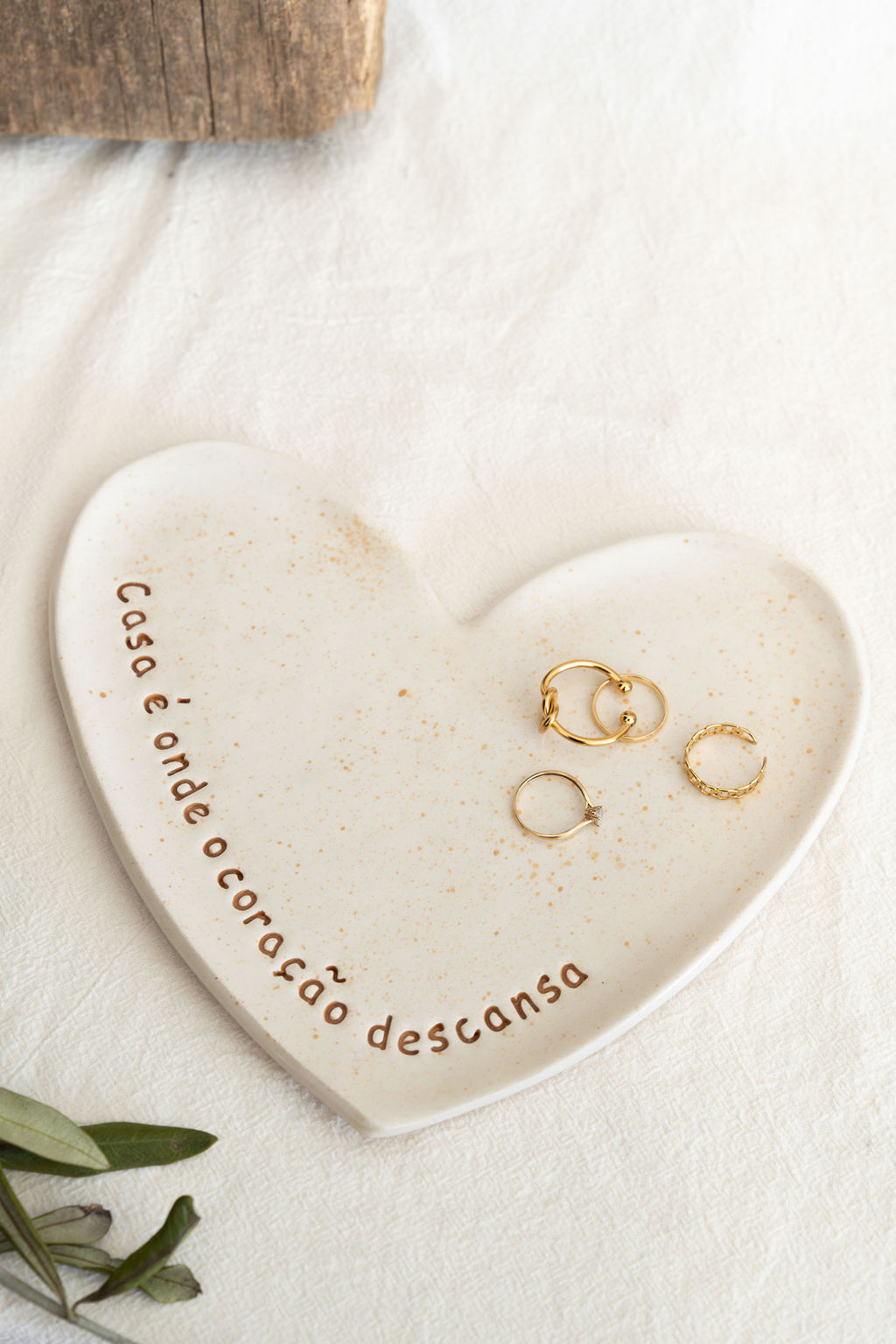 Prato coração em cerâmica creme com texto e anéis dourados
