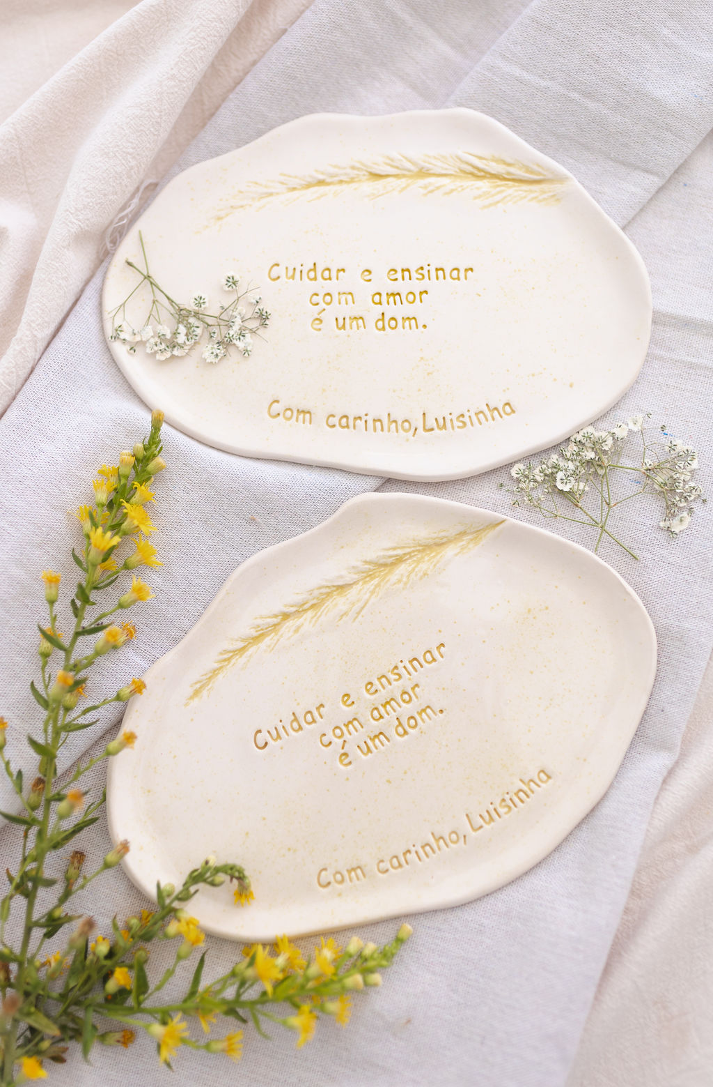 Placas decorativas brancas com gravações douradas e flores secas
