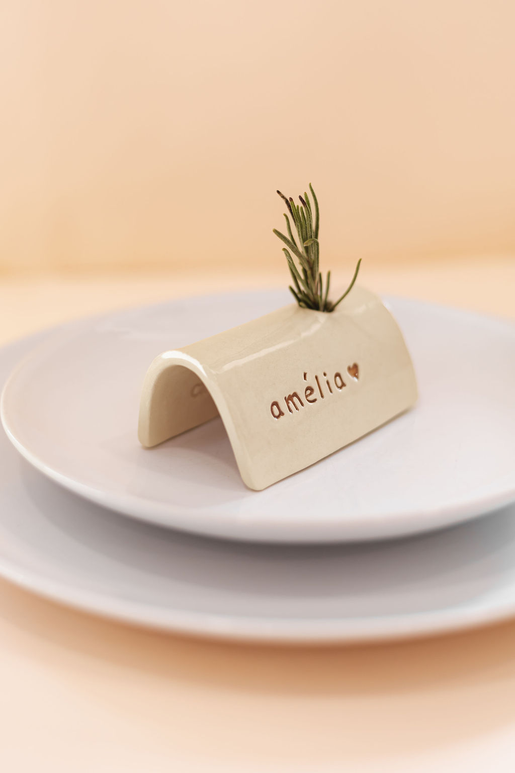 Suporte de cerâmica arqueado com a palavra amélia e ramo de alecrim