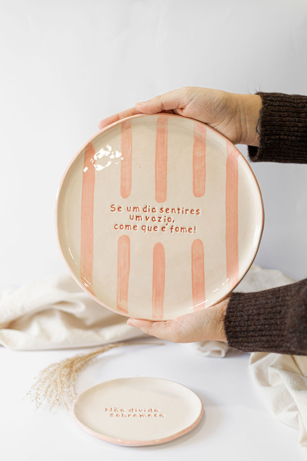 Conjunto de dois pratos de cerâmica com riscas cor-de-rosa e texto em português