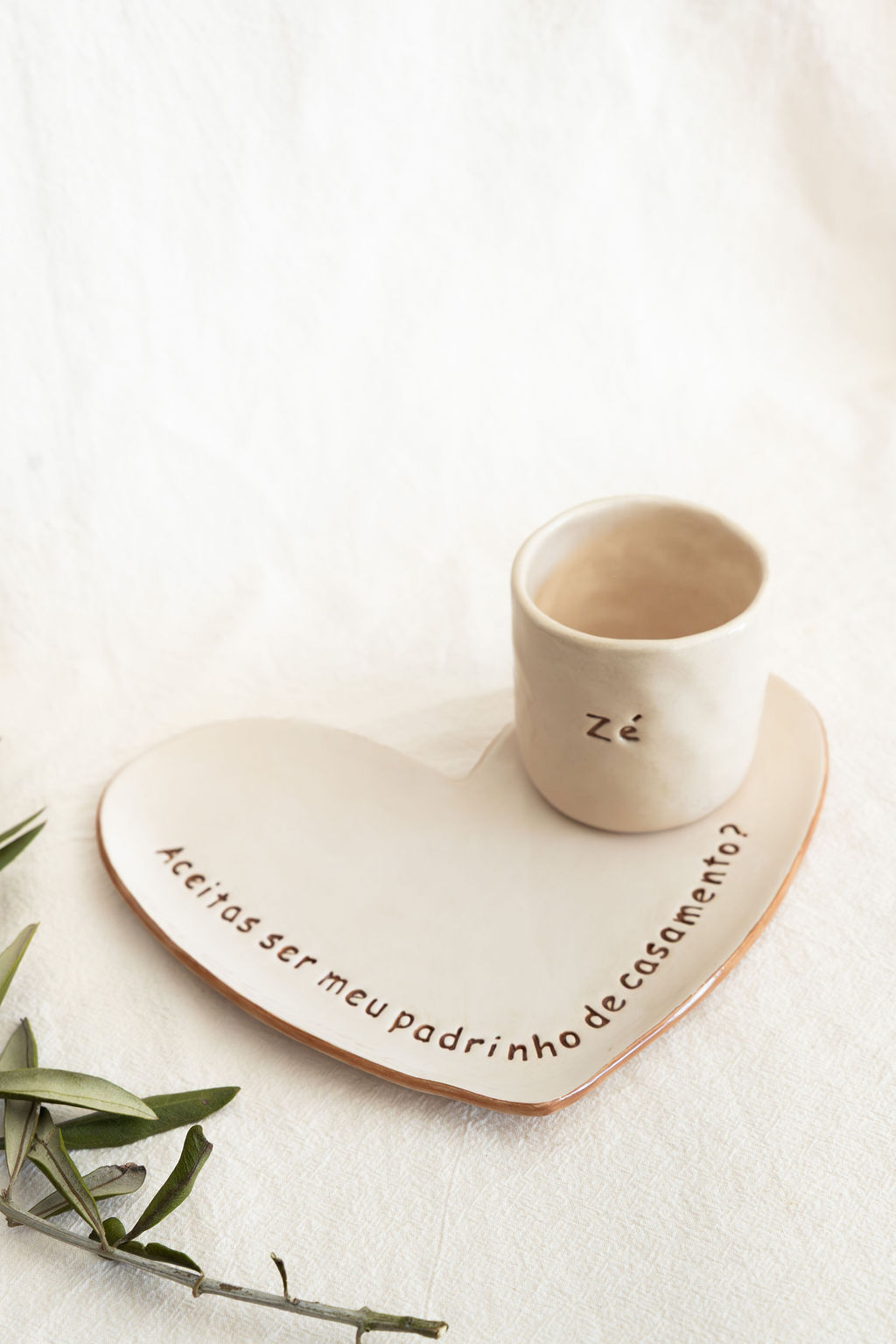 Conjunto de cerâmica com copo e prato coração com texto em português.