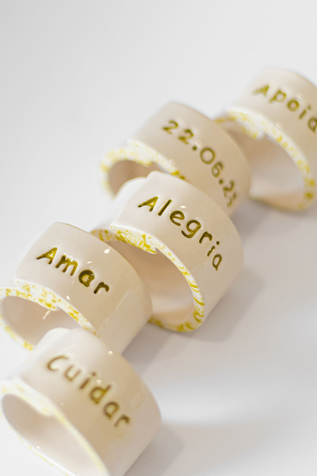 Anéis cerâmicos brancos com palavras gravadas a verde