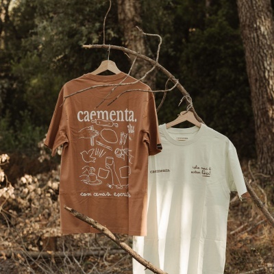 Duas t-shirts em cabides penduradas numa árvore em ambiente natural