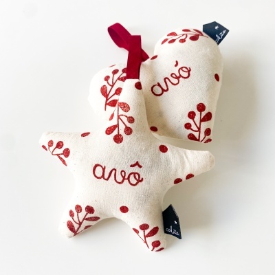 Almofadas decorativas em forma de estrela e coração brancas com padrão de ramos vermelhos e texto 