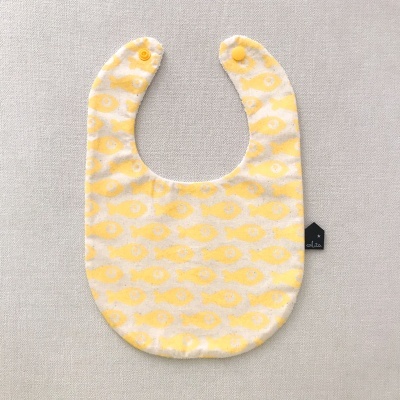 Babete de bebé branco com peixes amarelos e fechos de pressão