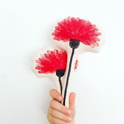 Almofada branca com estampa de flores vermelhas e pretas