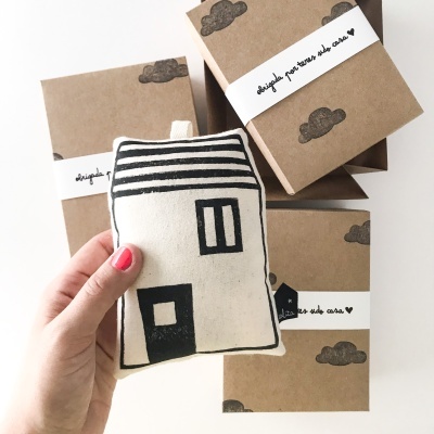 Almofada com desenho de casa e caixas de embalagem com texto e nuvens