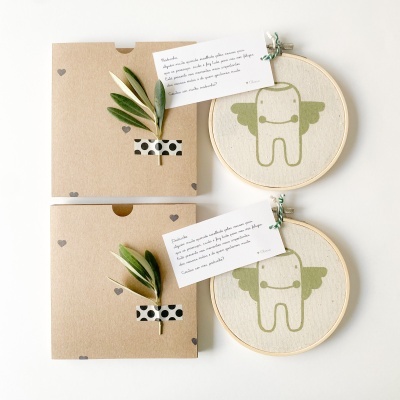 Dois kits de presente com caixas decoradas, cartões e bastidores de bordado com desenho de dente com asas verdes