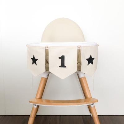 Cadeira alta de madeira com banner decorativo branco e preto, número 1 e estrelas