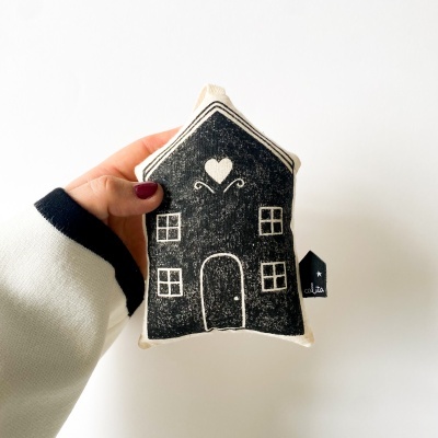 Pelúcia em forma de casa preta e branca com desenhos e etiqueta