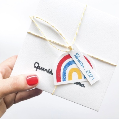 Caixa branca pequena amarrada com corda e etiqueta de arco-íris