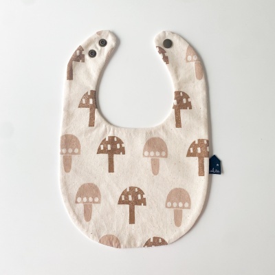 Babete de bebé em algodão com padrão de cogumelos castanhos e bege