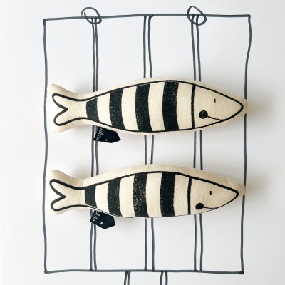 Brinquedo de tecido em forma de peixe com riscas pretas