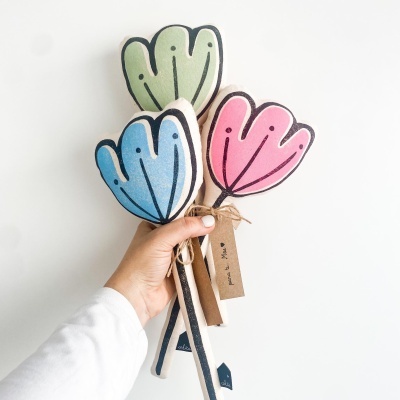 Flores decorativas de tecido coloridas seguradas por uma mão