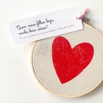 Aro de bordado com coração vermelho estampado e etiqueta com texto em português
