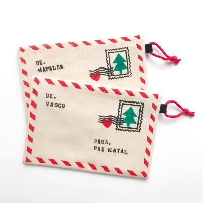 Dois saquinhos de tecido com padrão de envelope postal e textos de remetente e destinatário