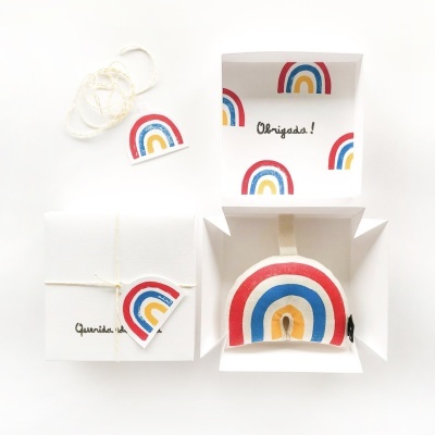Conjunto de presente com padrão de arco-íris e caixas brancas com texto Obrigadas