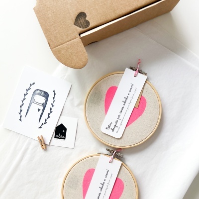 Dois bastidores de tela com corações rosas e cartões sobre superfície branca