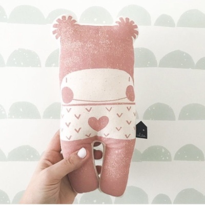 Boneco de peluche cor-de-rosa com padrão de coração e dois círculos na face