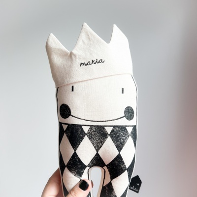 Peluche branco e preto com coroa e nome bordado sendo segurado