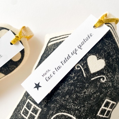 Bonecos tecidos pretos e brancos com etiqueta de Natal e cordão dourado