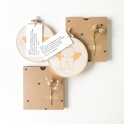 Dois aros de bordado com desenhos simples, dois envelopes decorados com corações e ramos secos, cartões com texto em inglês.