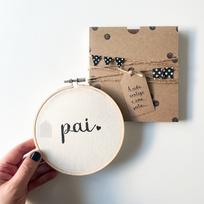 Moldura redonda de bordado com a palavra pai e caixa decorada ao lado.