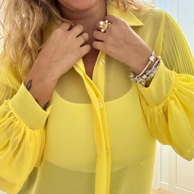 Blusa amarela translúcida com mangas bufantes e acessórios femininos