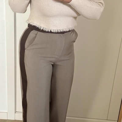 Camisola creme de malha com barra irregular e calças bege com risca castanha lateral em interior.