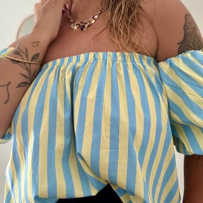 T-shirt ombro a ombro riscas amarelas e azuis com acessórios e tatuagens.