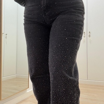 Calças pretas justas com pequenos detalhes brilhantes