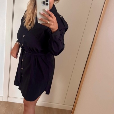 Vestido preto curto com botões e cinto, botas pretas e espelho