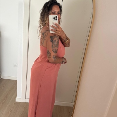 Mulher a tirar selfie ao espelho vestindo vestido longo salmão