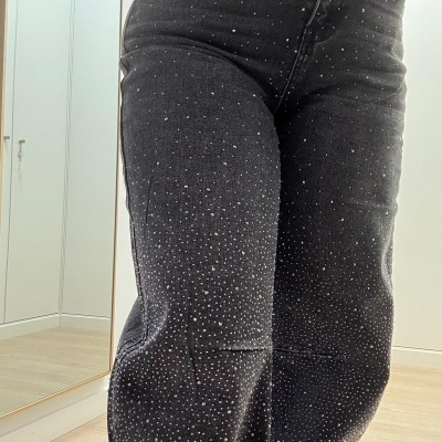 Calças de ganga negras com pequenos brilhos em padrão espalhado