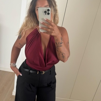 Blusa vinho com decote em V fundo e calças pretas largas com cinto