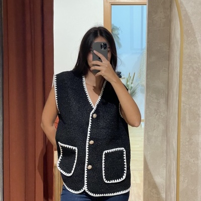 Colete feminino preto com bordas brancas e botões em espelho