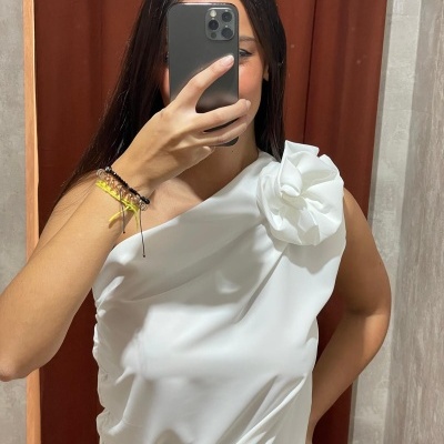 Top branco com alça única e flor decorativa no ombro
