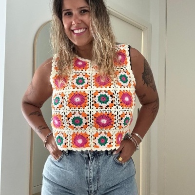 Top de crochet colorido e calças jeans em interior com espelho