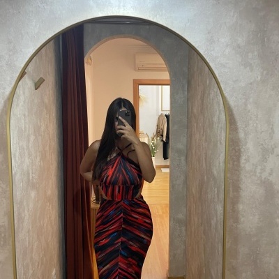 Vestido longo com padrão geométrico vermelho e azul, refletido em espelho dourado