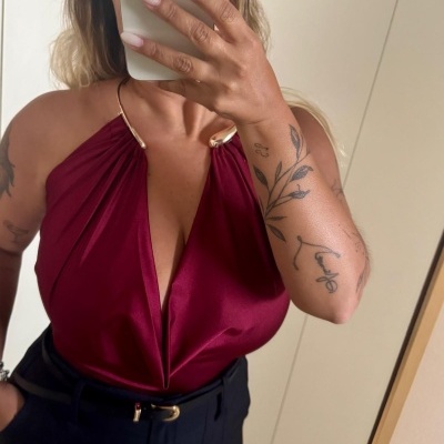 Blusa vermelha vinho com decote profundo e alças metálicas douradas e calças pretas com cinto