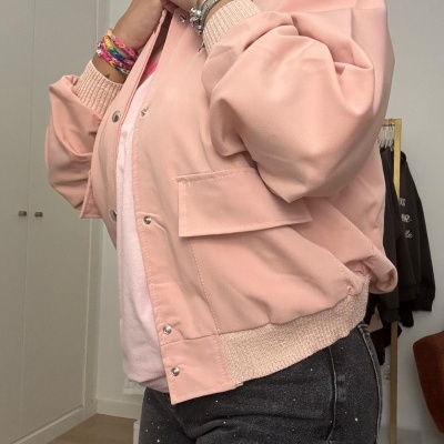 Blusão rosa claro com botões e calças pretas com manchas brancas